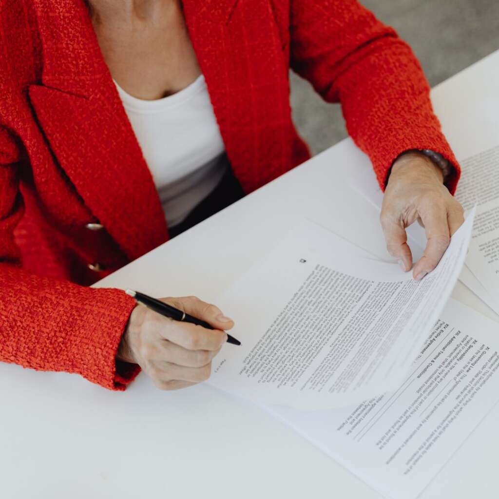 Business professional reviewing redomestication contracts with notes.